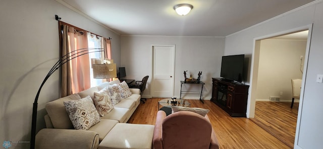 living room with light hardwood / wood-style flooring and crown molding