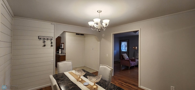 dining space featuring an inviting chandelier, crown molding, and dark hardwood / wood-style flooring