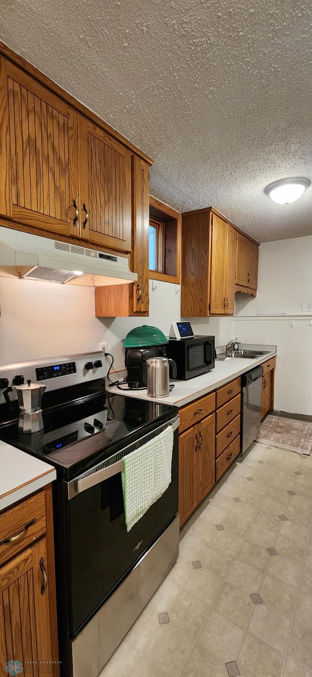 kitchen featuring appliances with stainless steel finishes, sink, and a textured ceiling