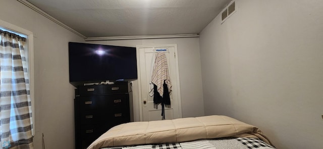 bedroom featuring crown molding and a textured ceiling