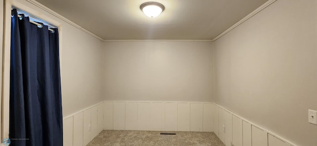 carpeted spare room featuring crown molding