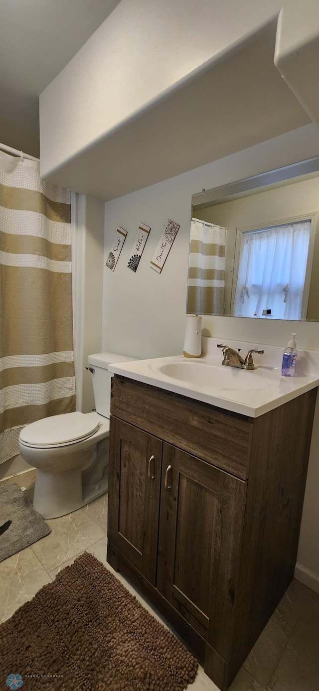 bathroom featuring tile patterned floors, toilet, walk in shower, and vanity