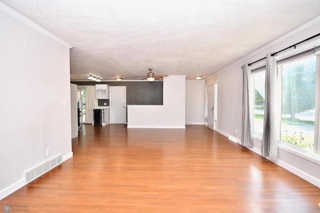 unfurnished living room with hardwood / wood-style flooring, a wealth of natural light, and a textured ceiling