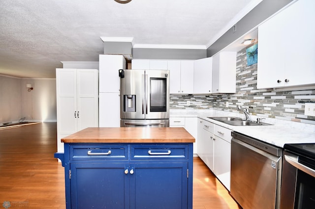 kitchen featuring light wood-type flooring, sink, white cabinetry, appliances with stainless steel finishes, and blue cabinets