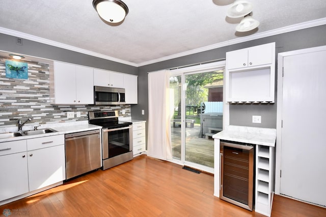 kitchen with wine cooler, stainless steel appliances, light wood-type flooring, and sink