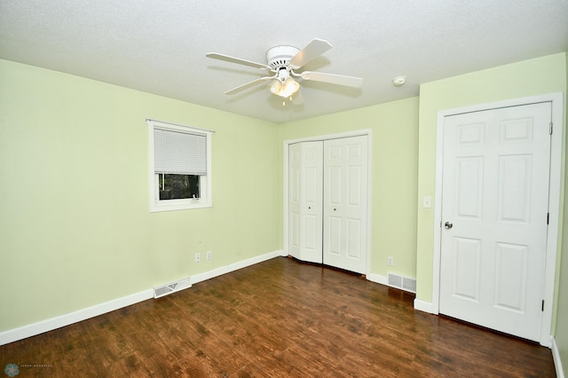 unfurnished bedroom featuring ceiling fan, a textured ceiling, and dark hardwood / wood-style flooring