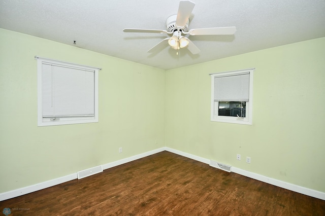 empty room featuring a textured ceiling, ceiling fan, and dark hardwood / wood-style flooring