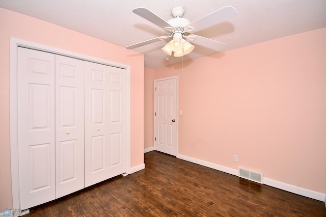 unfurnished bedroom featuring ceiling fan, a closet, and dark hardwood / wood-style flooring