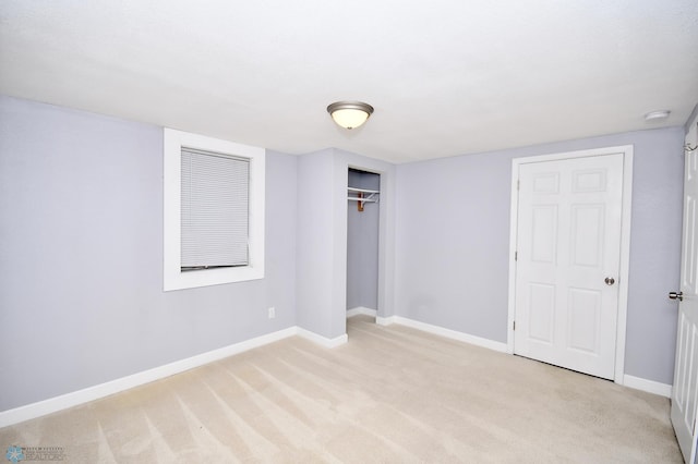 unfurnished bedroom featuring light colored carpet and a closet