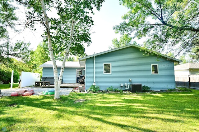 back of property featuring central air condition unit, a lawn, and a patio area