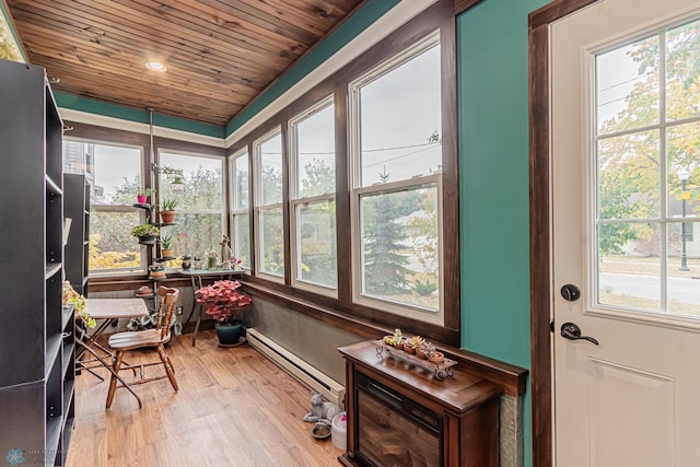 sunroom with baseboard heating, wooden ceiling, and a wealth of natural light