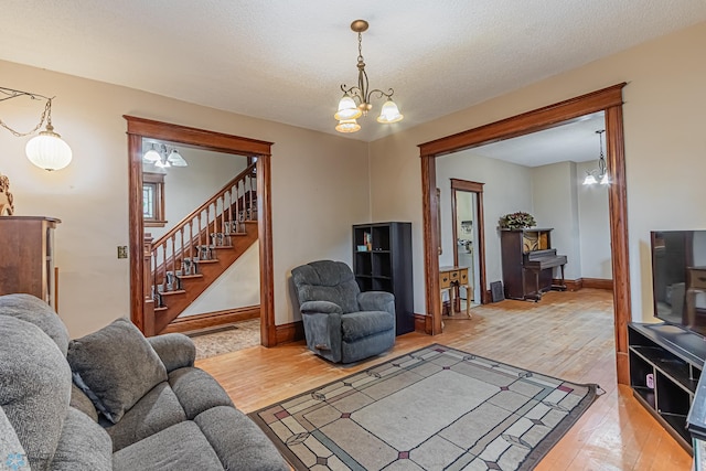 living room featuring hardwood / wood-style floors, an inviting chandelier, and a textured ceiling