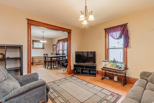 living room featuring hardwood / wood-style flooring, a notable chandelier, and a textured ceiling