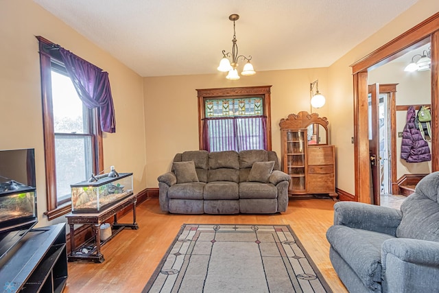 living room featuring an inviting chandelier and light wood-type flooring