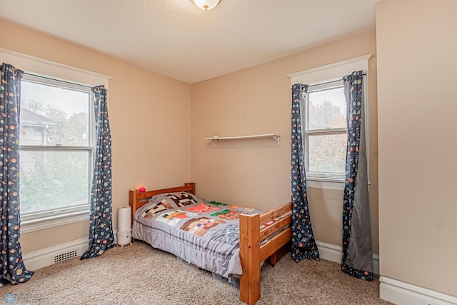 carpeted bedroom featuring multiple windows