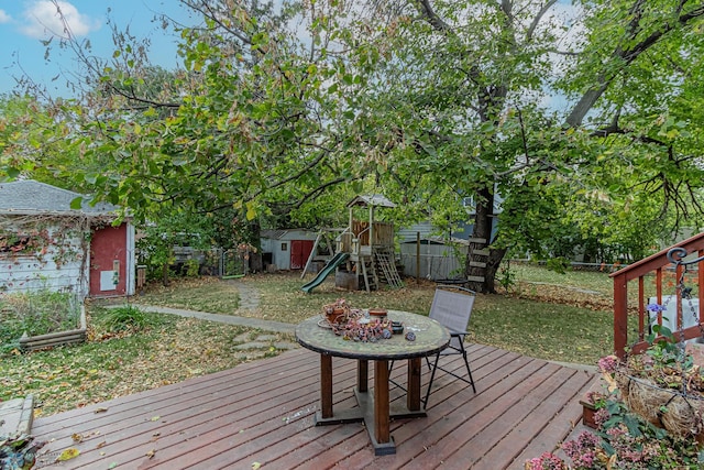 deck with a playground, a shed, and a lawn