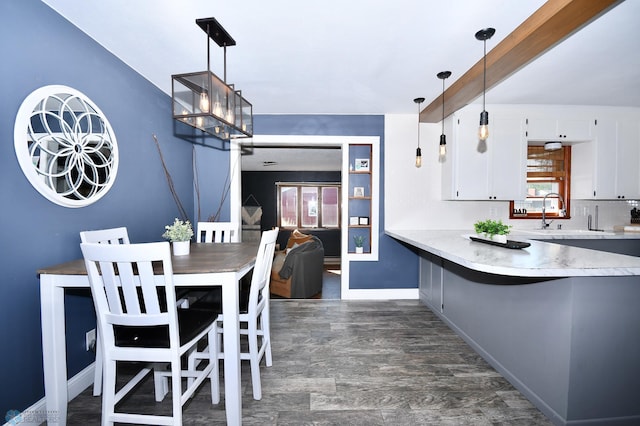 kitchen featuring white cabinets, pendant lighting, and a healthy amount of sunlight