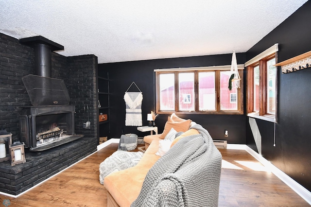 living room with baseboard heating, hardwood / wood-style floors, and a textured ceiling