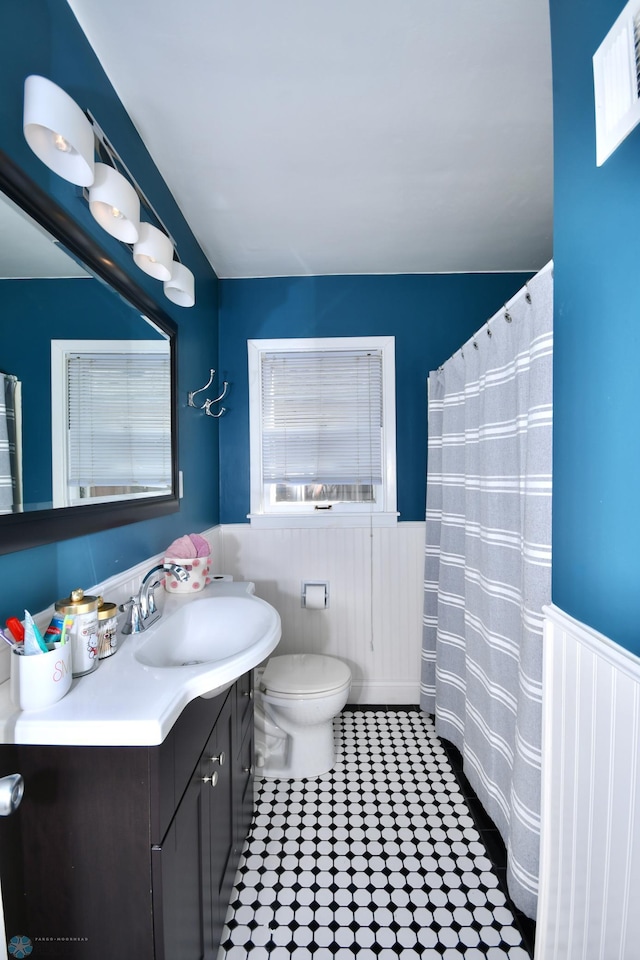 bathroom featuring walk in shower, vanity, and toilet