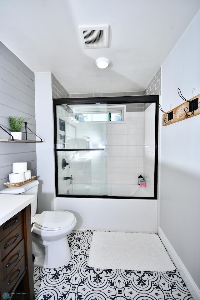 full bathroom with tile patterned flooring, enclosed tub / shower combo, vanity, and toilet