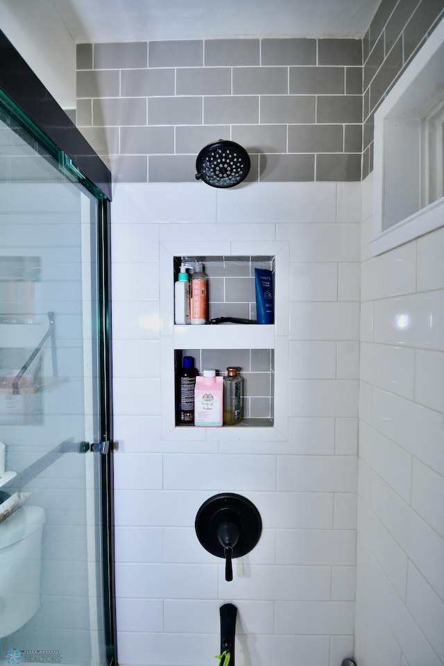 bathroom featuring a shower and toilet