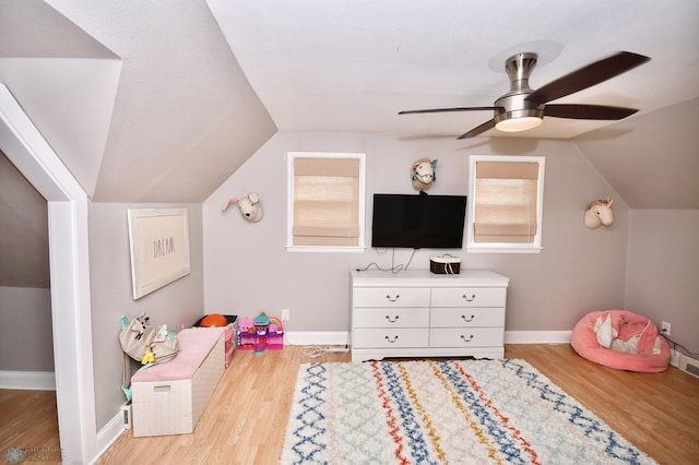 rec room with ceiling fan, light hardwood / wood-style flooring, vaulted ceiling, and a healthy amount of sunlight