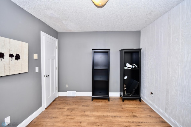 unfurnished bedroom featuring wood-type flooring and a textured ceiling