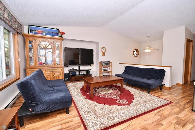 living room featuring ceiling fan, a textured ceiling, lofted ceiling, and hardwood / wood-style floors