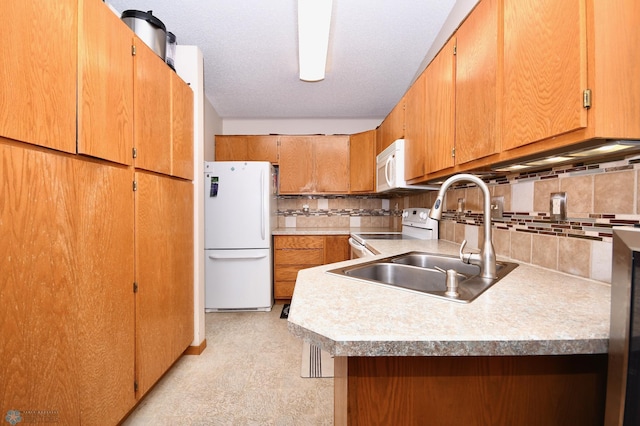 kitchen featuring tasteful backsplash, white appliances, sink, kitchen peninsula, and a textured ceiling