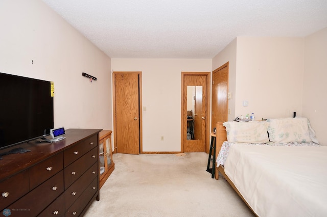 bedroom featuring light colored carpet and a textured ceiling