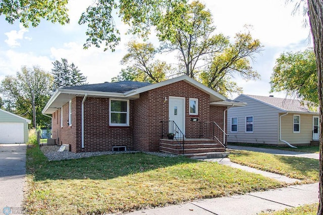 bungalow-style home featuring a garage, a front yard, an outbuilding, and central AC unit