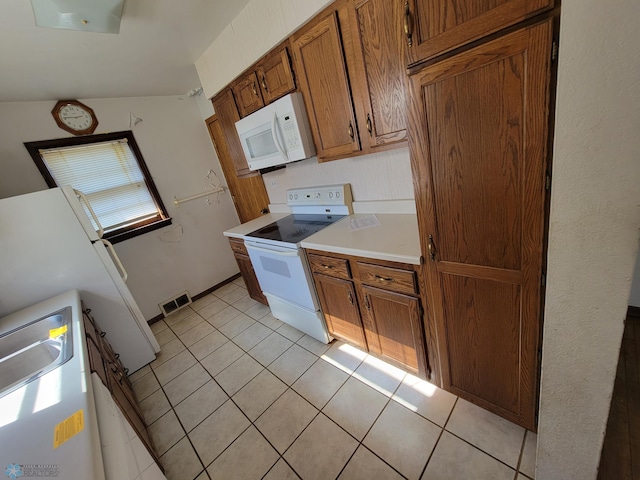 kitchen featuring light tile patterned floors and white appliances