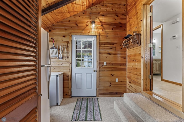 entryway with light carpet, wood walls, vaulted ceiling, and wooden ceiling