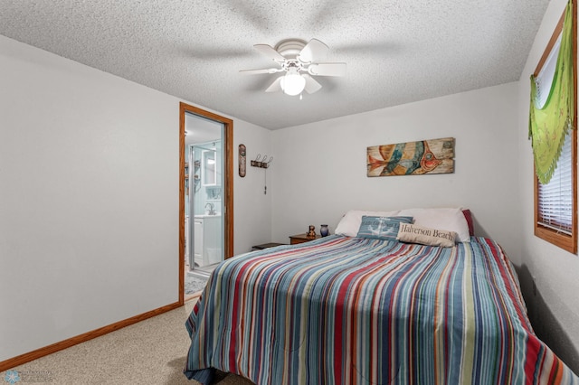 carpeted bedroom featuring ceiling fan, connected bathroom, and a textured ceiling