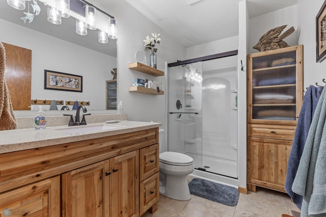 bathroom featuring tile patterned floors, toilet, a shower with door, and vanity