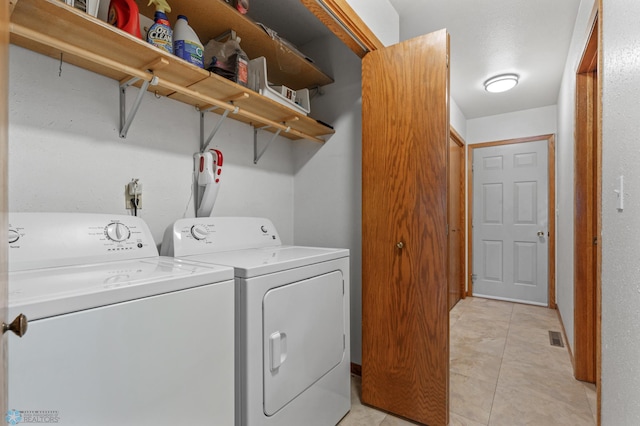 laundry area featuring washer and clothes dryer and light tile patterned floors