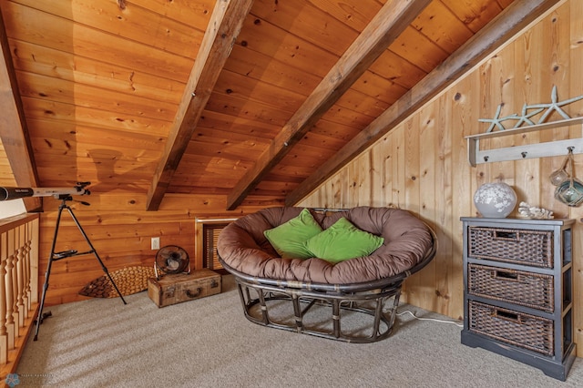 living area with beamed ceiling, wooden walls, wood ceiling, and light colored carpet