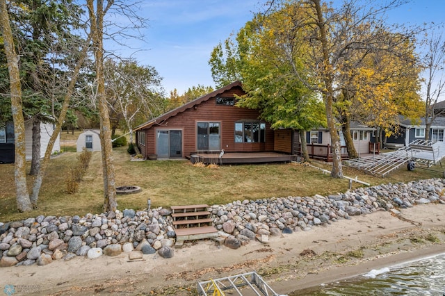 view of front of property featuring a storage unit and a wooden deck