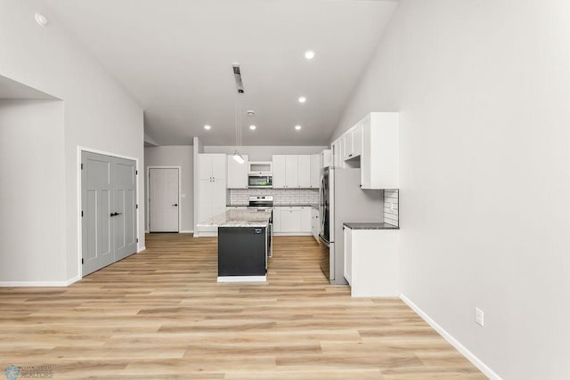 kitchen with light hardwood / wood-style flooring, white cabinets, stainless steel appliances, and a kitchen island