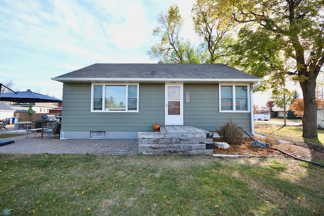 bungalow featuring a front yard and a patio area