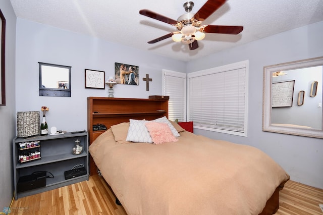 bedroom featuring a textured ceiling, light hardwood / wood-style floors, and ceiling fan