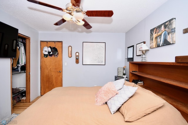 bedroom featuring a textured ceiling, wood-type flooring, and ceiling fan