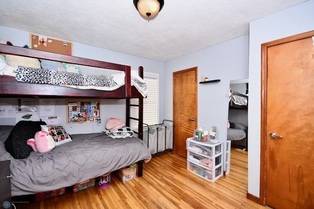 bedroom featuring hardwood / wood-style floors and a textured ceiling