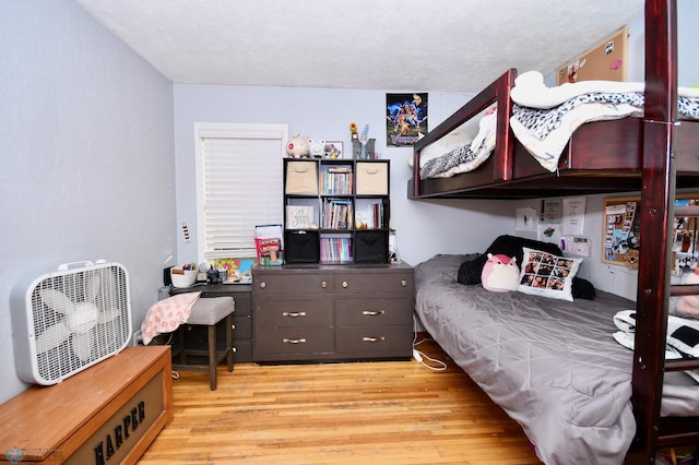 bedroom with light hardwood / wood-style flooring and a textured ceiling