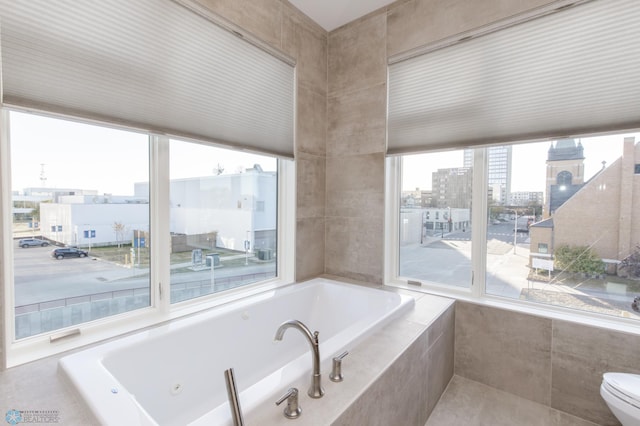 bathroom with tiled tub and toilet