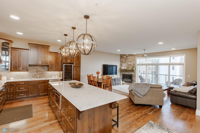 kitchen with light hardwood / wood-style floors, a center island, pendant lighting, and a kitchen breakfast bar