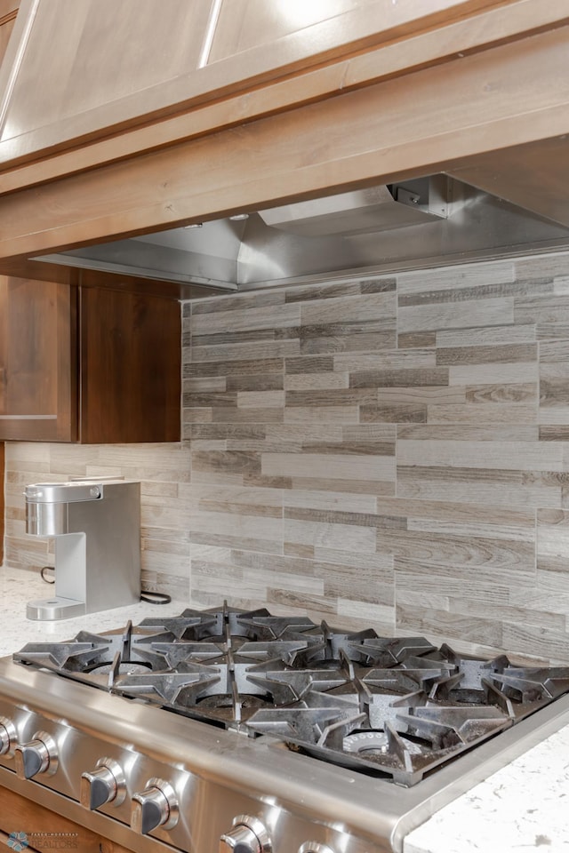 details with stone counters, stainless steel range, and tasteful backsplash