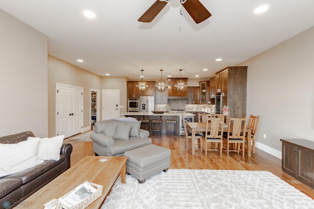 living room featuring light hardwood / wood-style flooring and ceiling fan