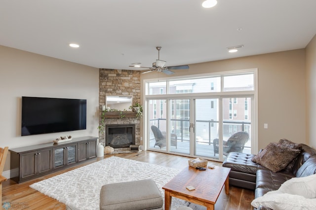 living room with ceiling fan, a fireplace, and hardwood / wood-style floors