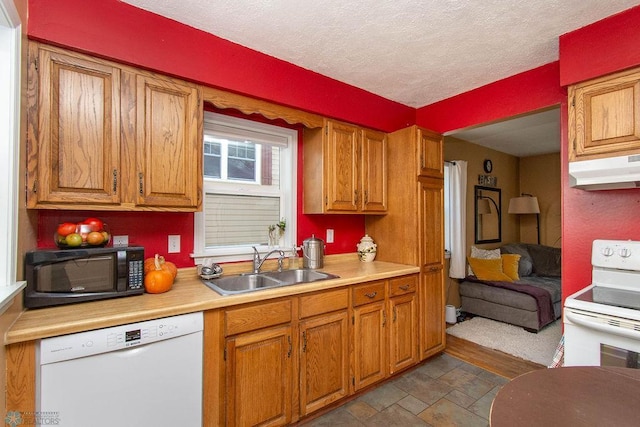 kitchen with a textured ceiling, sink, and white appliances